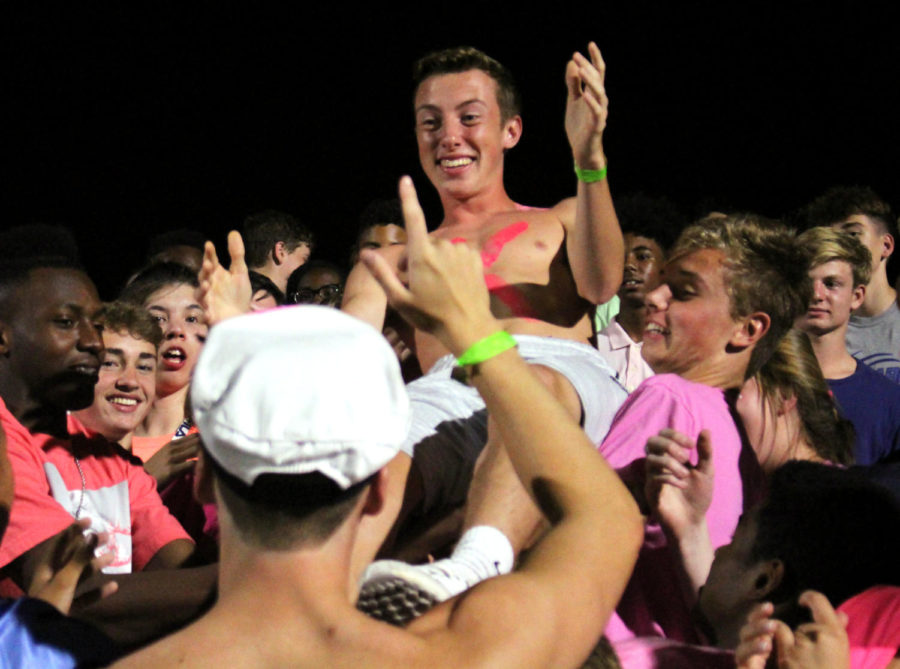 Senior Matthew Bousch is lifted by junior Johnathan Hill while crowd surfing the fan section of the October 13th Homecoming game. Bousch being lifted by his fellow classmates and carried around would make his final homecoming game an unforgettable one.
