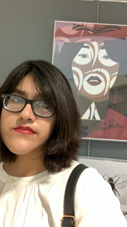 Senior Ivonee Morales-Mejia attends the North Kansas City School District art exhibit at Gladstone Community Center on Thursday, March 12. She stands with her piece ‘Carmen,’ which was chosen to represent Oak Park High School in the exhibit.  