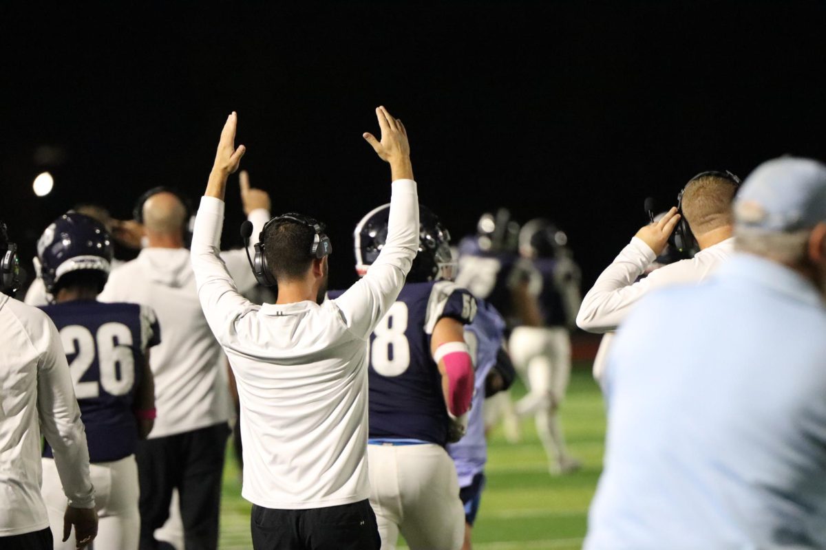 Assistant coach Thomas Gratto raises his arms as Oak Park scored a touchdown against St. Joe Central on Friday, Oct. 4. “We played confidently and executed our game plan well,” Gratto said. This good performance led the Northmen to
win 52-13.