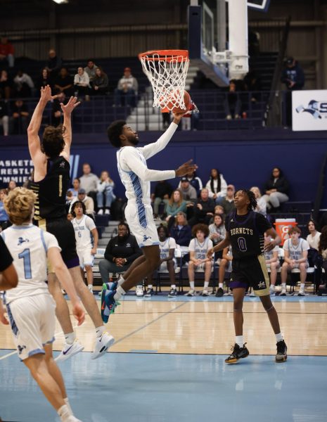 WHO ARE YOU GUARDING Senior Corbin Allen does a layup after passing by the North Kansas City defender Friday, Jan. 10. The Northmen defeated the Hornets 74-65 in the district game.