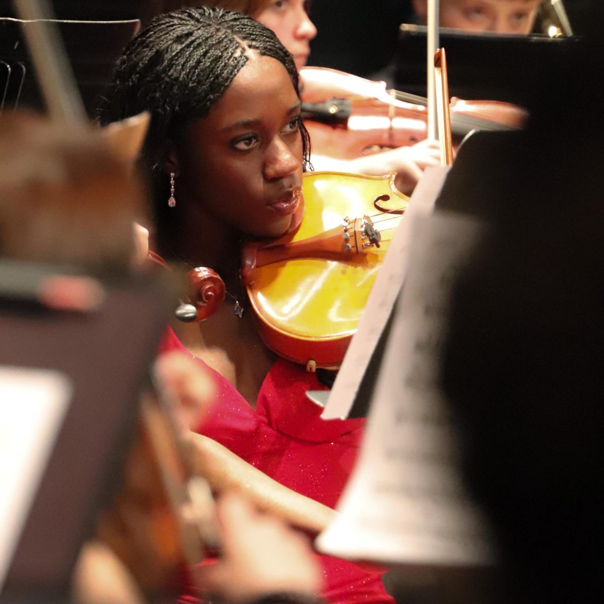 Intently focused on her music, Senior Agneezer Barole sits in her stunning red prom dress during her last concert of her high school career on April 28th. 